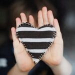 hands holding striped heart