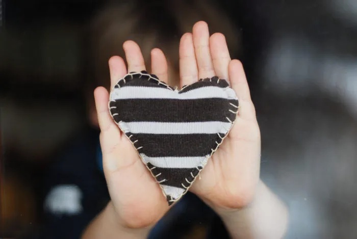 hands holding striped heart