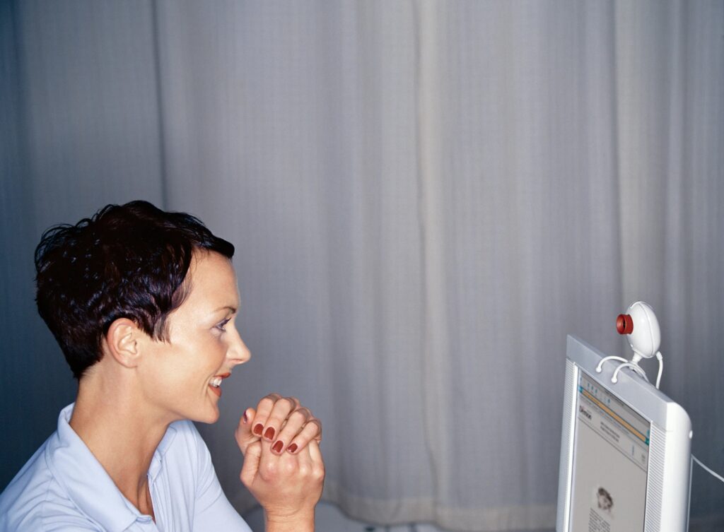 Person on virtual meeting; woman looking at computer