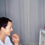 Person on virtual meeting; woman looking at computer